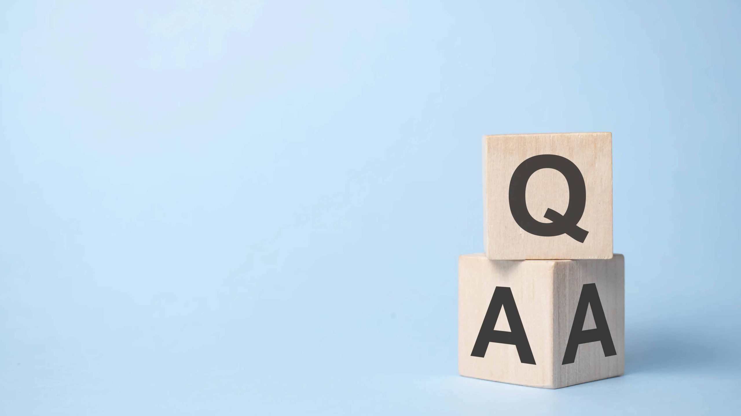 水色の背景にQ＆Aの木のブロックが置かれている画像