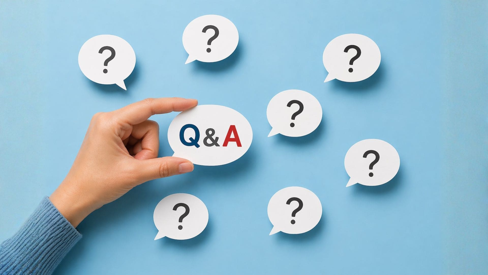 複数の疑問符に囲まれた「Q&A」の吹き出しを手に持つ様子